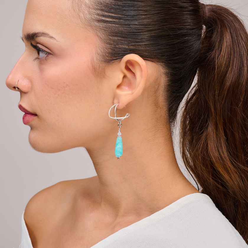 עגילי כסף מעוצבים עם אמזונייט טבעי – אבן בגוון תכלת-ירקרק המשדרת רוך, בהירות ושקט פנימי. תכשיט בעיצוב נקי וקליל, שמתאים לכל סגנון לבוש – קז'ואלי, בוהו או אלגנטי. עגילים נוחים וקלי משקל, מתאימים לענידה יומיומית או לאירועים רגועים. הבחירה המושלמת לנשים שמתחברות לאנרגיה של טבע ושלווה.

