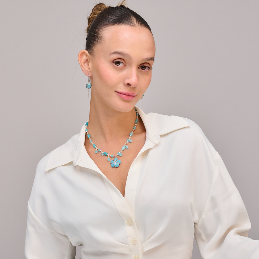 שרשרת בגוון תכלת שקוף-חלבי עם תליון פרח מתכתי או חרוזי – עיצוב שמשלב פשטות עם אלגנטיות טבעית. עבודת יד מדויקת עם תשומת לב לכל פרט – מחזירה אותנו לפשטות הקסומה של החיים.