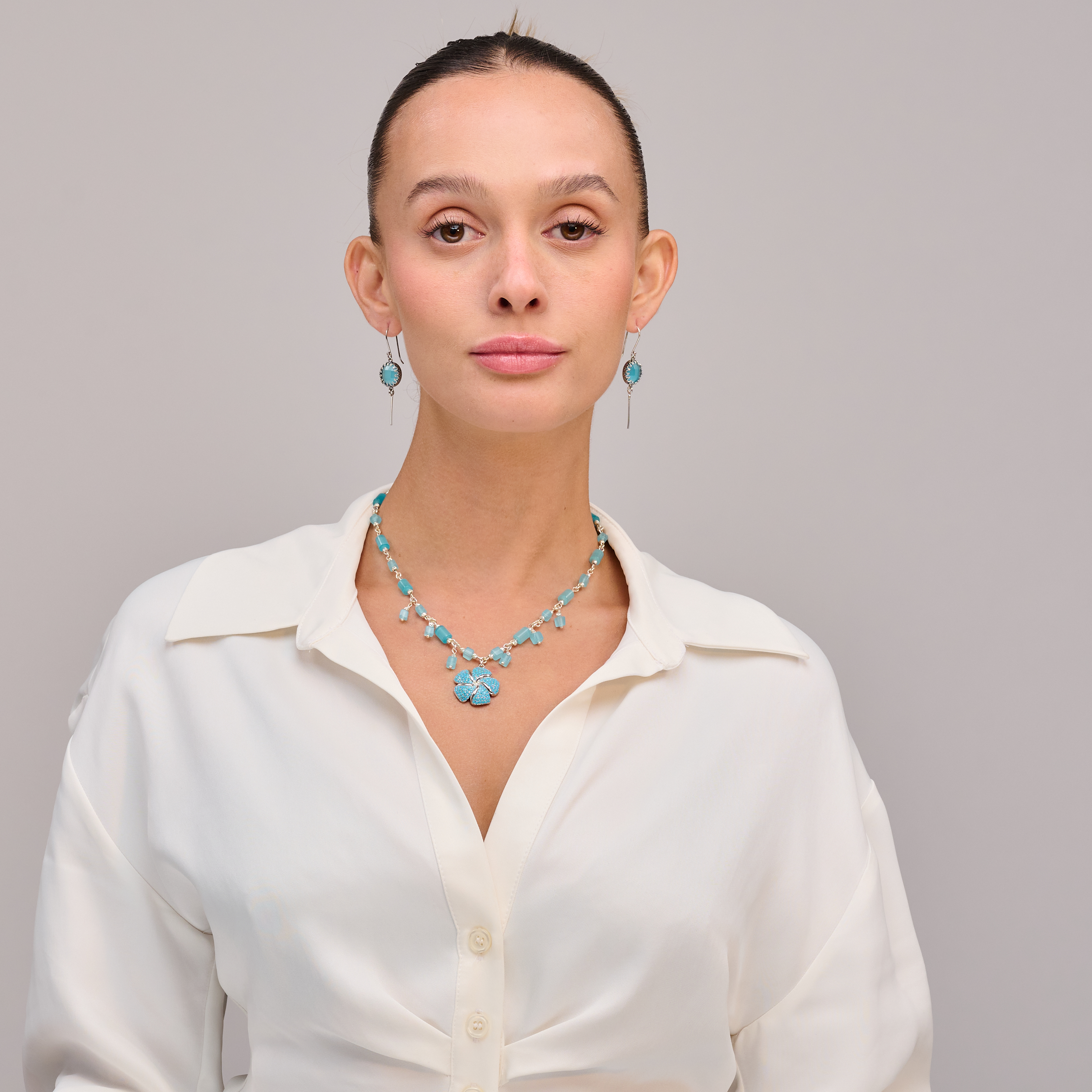 שרשרת בגווני תכלת קרים עם תליון פרח יחיד שמוסיף חמימות ועדינות – תכשיט שמדגיש את היופי בפשטות. שילוב עדין בין צבע ואור, פרח ותכלת – יוצר מראה קליל ומלא אופי.