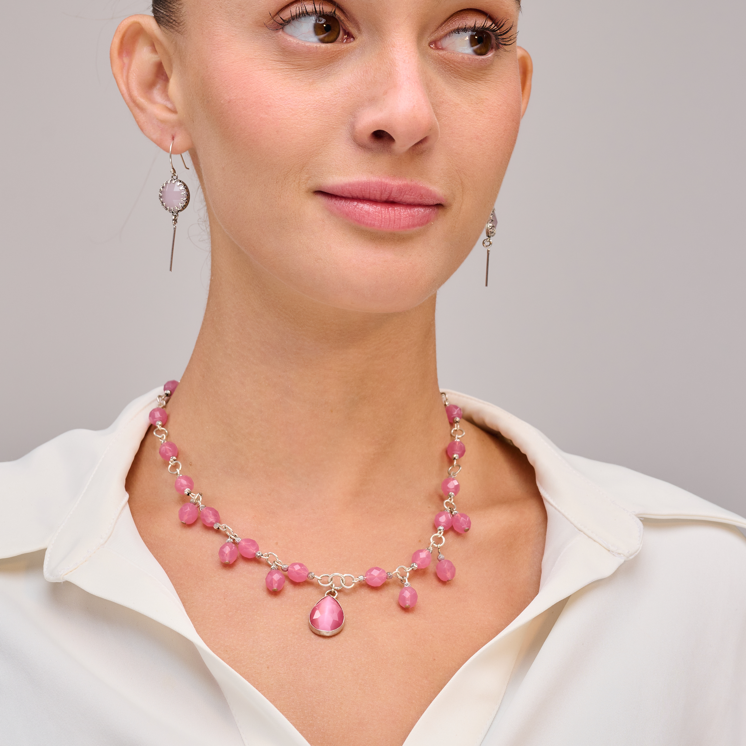 שרשרת בגווני ורוד רך ועמוק, עם אבנים בעלות ברק פנימי ייחודי – אפקט עין חתול שמשדר אלגנטיות מסתורית. מתאימה לנשים שאוהבות תכשיטים עם טקסטורה חזותית ותנועה עדינה – אלגנטיות ייחודית בכל מבט.