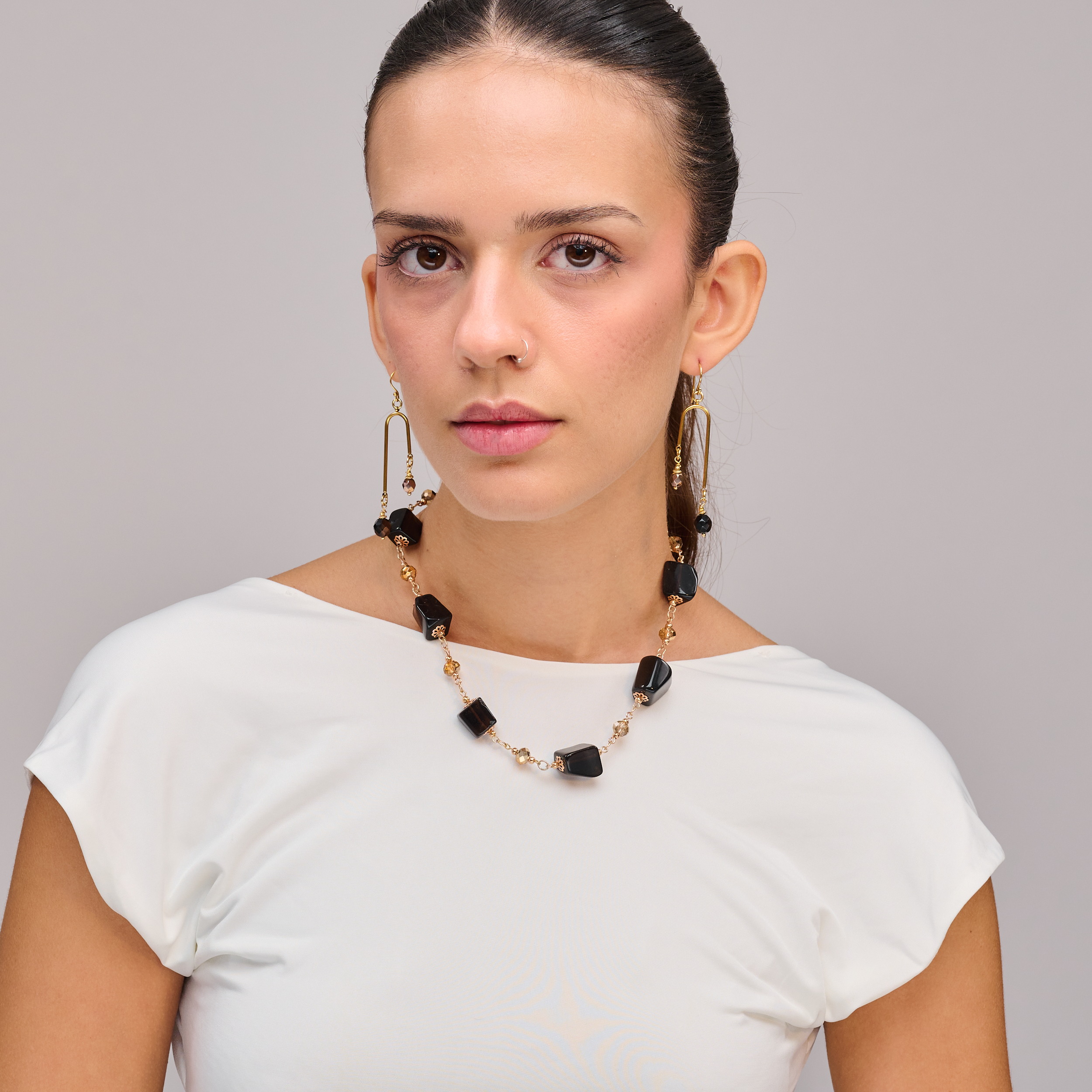 שרשרת אבנים שחורות בעבודת יד – תכשיט אלגנטי ומלא נוכחות עם אבני חן בגימור מבריק, בגווני שחור עמוק ופנינתי. מראה קלאסי ונצחי שמוסיף עומק ועוצמה לכל הופעה. תכשיט שמתאים לערב, למראה דרמטי או כטאץ’ מתוחכם ליום-יום.