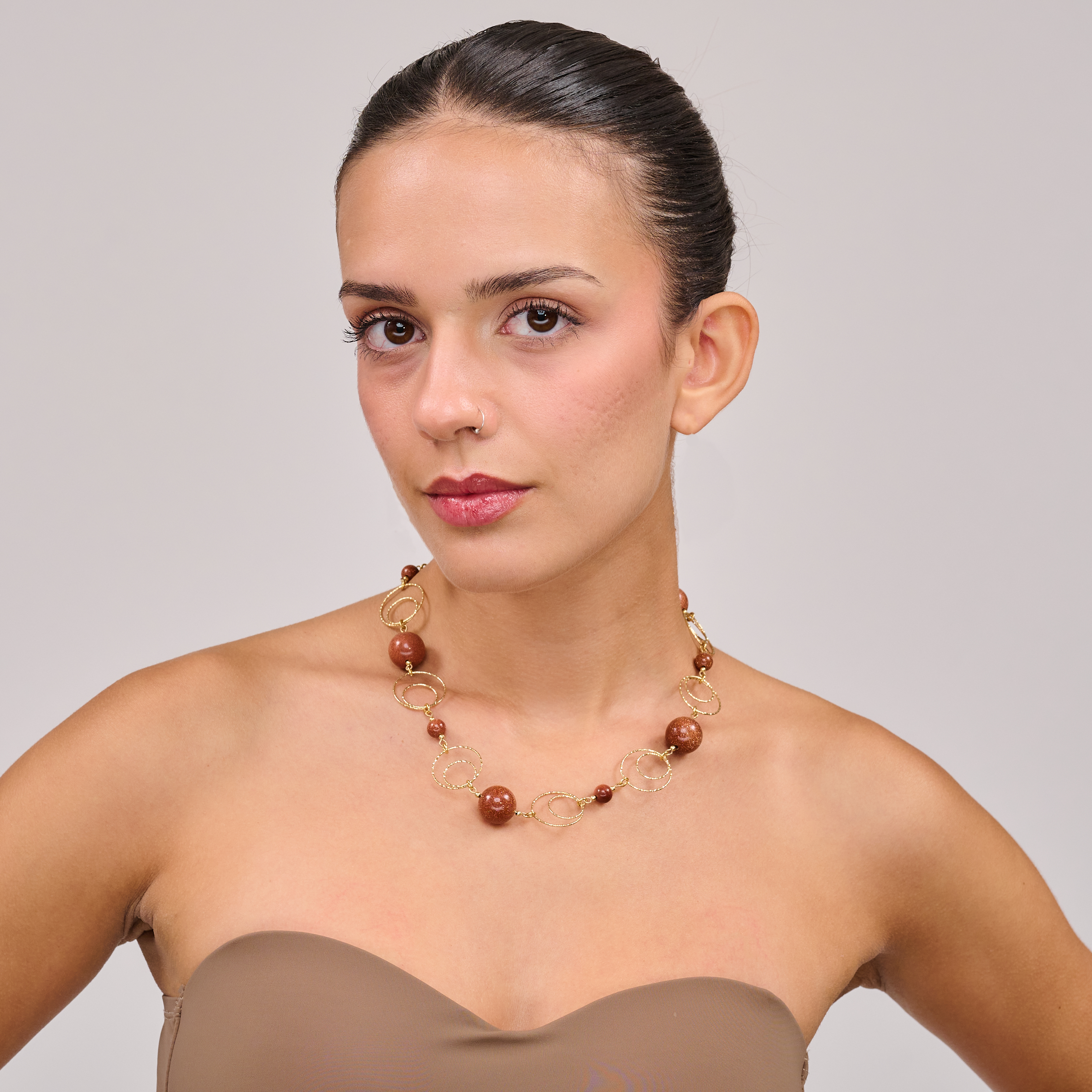 תכשיט בעבודת יד עם אבני אוונטיורין חומות בגימור מבריק־מט, המשלבות גווני חום קפה עם נצנוץ פנימי עדין. כל אבן מקרינה עומק צבע וחום פנימי, והשרשרת יוצרת נוכחות רגועה אך מורגשת. אידיאלית לנשים שמחפשות יופי אותנטי וייחודי, כזה שמדבר בשפה של טבע, איזון פנימי ועיצוב הרמוני. התכשיט משתלב בצורה מושלמת עם לבוש בגווני קרם, ירוק זית או כתום כהה, ומתאים במיוחד לעונות המעבר.