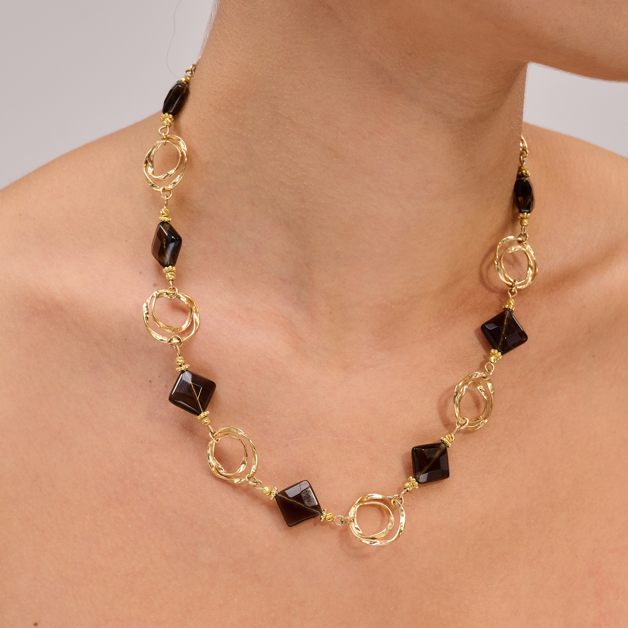 שרשרת בגוונים עמוקים של טופז חום – אבן טבעית המהדהדת יציבות, חמימות ועוצמה רגועה. כל אבן משולבת עם אלמנטים מצופי זהב, מעובדים בעבודת יד מוקפדת המוסיפה גימור קלאסי ומגע של יוקרה. תכשיט עם נוכחות עדינה אך יוקרתית, המתאים להופעות עם עומק וסטייל אישי לא מתאמץ.

