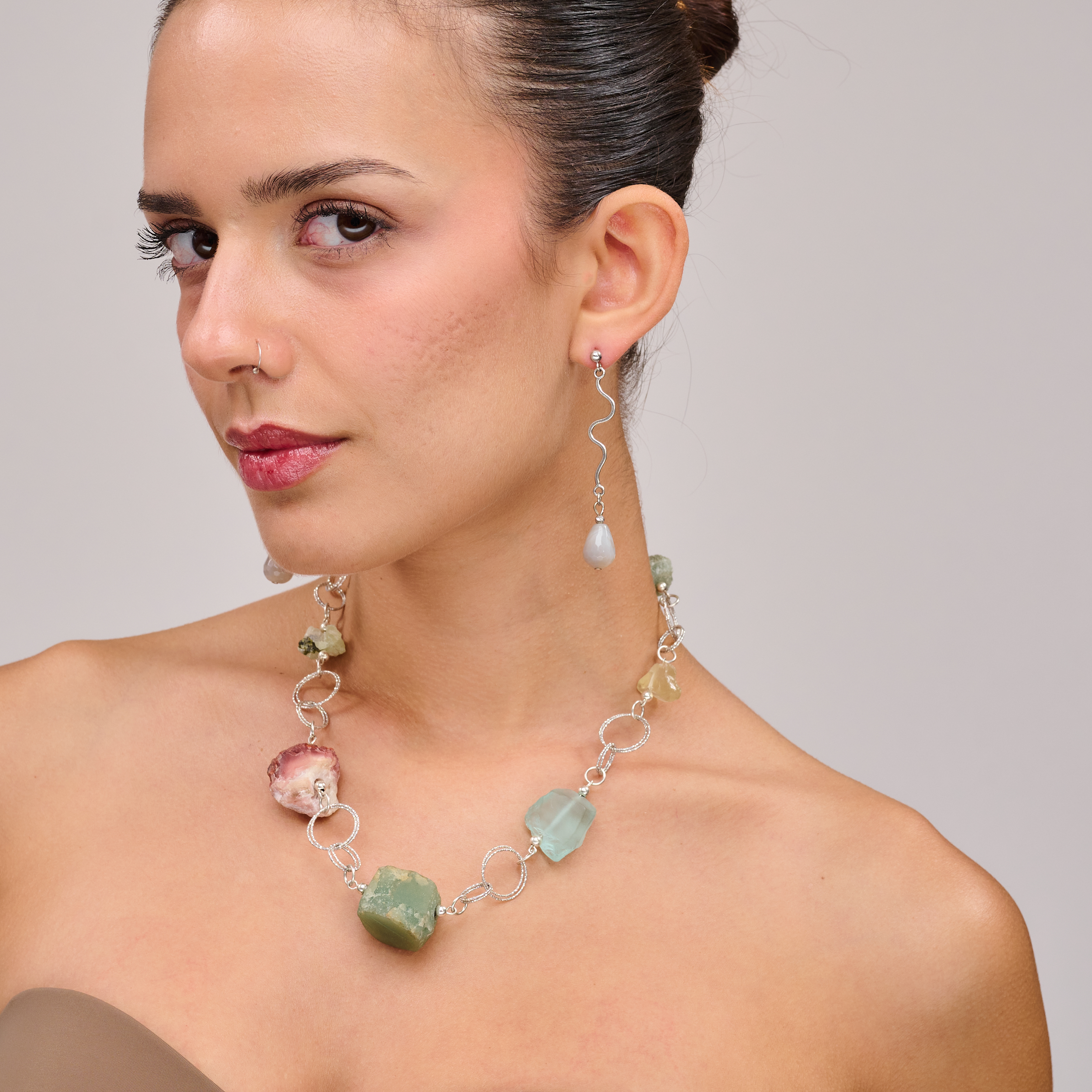 שרשרת כסף בעבודת יד שמשלבת קומבינציה אלגנטית של מינרלים חיים – אמטיסט בגוון סגול עמוק, רוז קוורץ ורדרד ורך, פלואוריט בגוני ירוק וסגול שקופים, וקרנליאן חם בצבע כתום־אדמדם. ההמפגש בין האבנים יוצר איזון אנרגטי עם עומק רגשי ואנרגטי, וכל אבן מוסיפה שכבה משלה של משמעות ונוכחות. השרשרת עוצבה כך שכל אבן תוכל לנשום, ומשלב ביניהן תוך כדי משחק של צבעים, טקסטורות ושקיפויות. השרשרת לנשים שמחפשות עומק ומשמעות באביזרים שלהן, כאלה שמתחברות לעוצמה שקטה ולסטייל ייחודי – וגם לאלו שמחפשות איזון, השראה ורוך. תכשיט שהוא גם יופי 