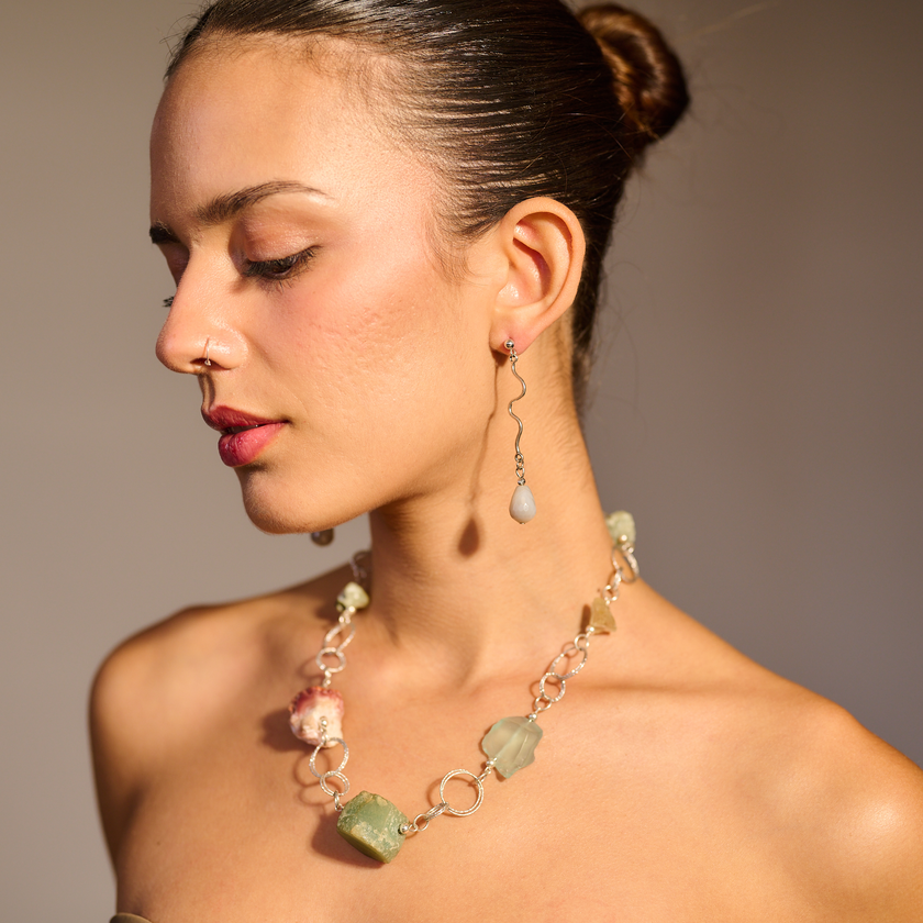 שרשרת כסף בעבודת יד שמשלבת מגוון עשיר של קריסטלים טבעיים – אמטיסט בגוון סגול עמוק, רוז קוורץ ורדרד ורך, פלואוריט בגוני ירוק וסגול שקופים, וקרנליאן חם בצבע כתום־אדמדם. ההמפגש בין האבנים יוצר איזון אנרגטי עם עומק רגשי ואנרגטי, וכל אבן מוסיפה שכבה משלה של משמעות ונוכחות. התכשיט מדגיש את הברק הטבעי והצבע של כל אבן, ומשלב ביניהן תוך כדי משחק של צבעים, טקסטורות ושקיפויות. השרשרת לנשים שמחפשות עומק ומשמעות באביזרים שלהן, כאלה שמתחברות לעוצמה שקטה ולסטייל ייחודי – וגם לאלו שמחפשות איזון, השראה ורוך. שרשרת שהיא כמו 