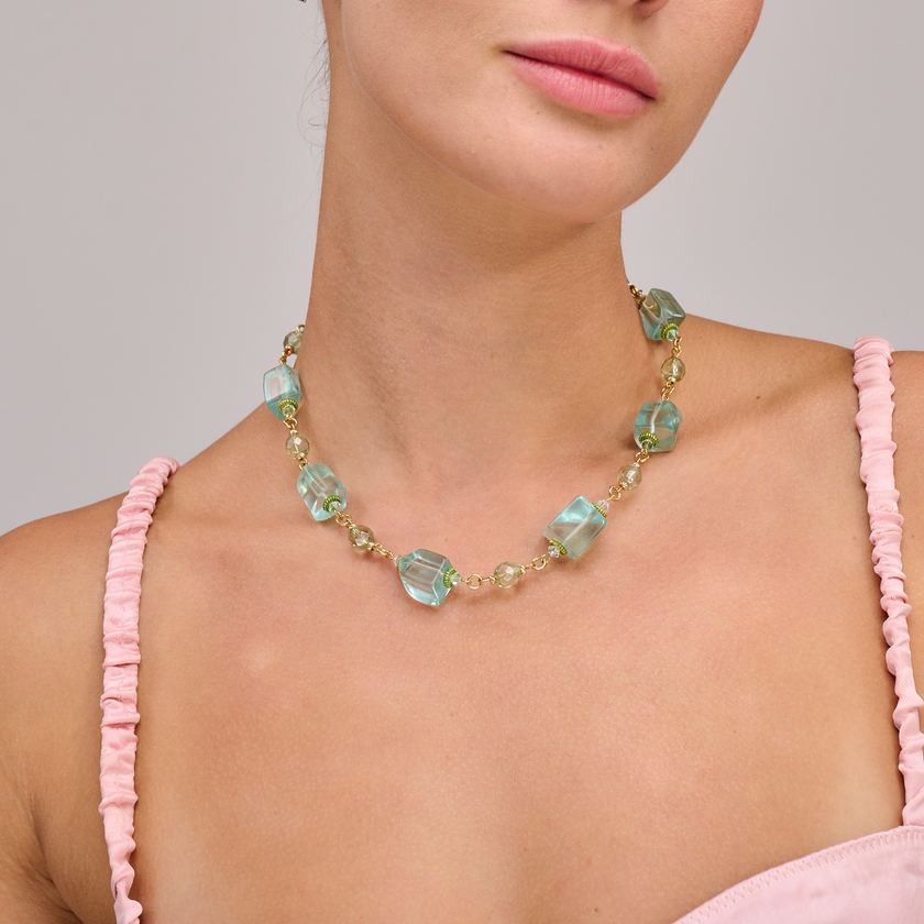 שרשרת בגווני כחול וטורקיז שמזכירה ימים חמים על שפת הים – החרוזים בצורות לא שגרתיות ועם ברק מעניין שמושך את העין, ומחוברים בעדינות בחוט מוזהב. מדובר בפריט בעבודת יד קפדנית, בעל נוכחות צבעונית על הצוואר. מתאים ללבישה יומיומית עם חולצה לבנה או כטאץ' צבעוני בשילוב עם שמלה אלגנטית – תכשיט קייצי מלא שיק עם וייבים של חופש.