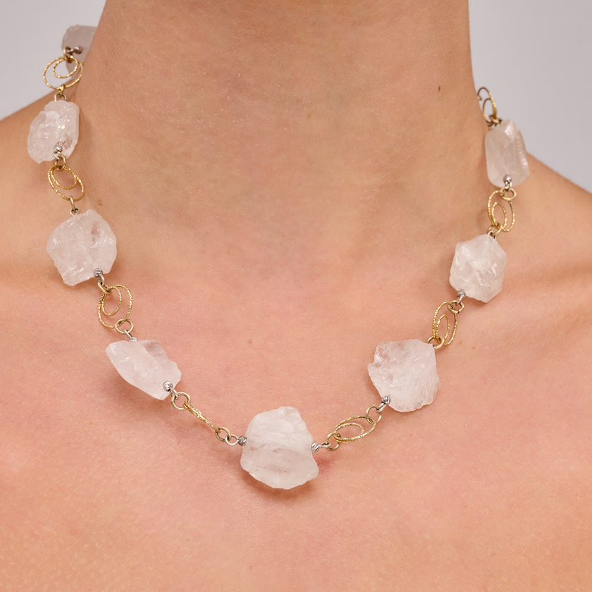 שרשרת כסף בציפוי זהב, בעבודת יד, עם קוורץ לבן בגימור חלק – תכשיט קלאסי עם מראה טהור, עדין ואלגנטי. הקוורץ הלבן מעניק מראה טהור ונקי, ומקרין אור רך שמתאים לכל גוון עור ולכל סגנון לבוש. ההציפוי הזהוב מחבר את המראה לעולם האלגנטי, ומשלים את הנוכחות של האבן בגימור מודרני ועדין. תכשיט מושלם למי שאוהבת שילוב של פשטות וסטייל, של ניקיון עיצובי עם נגיעה של זהר. מתאים ליום או ערב, לאירועים או ללבוש יומיומי – אלגנטי, מואר ומתאים תמיד.