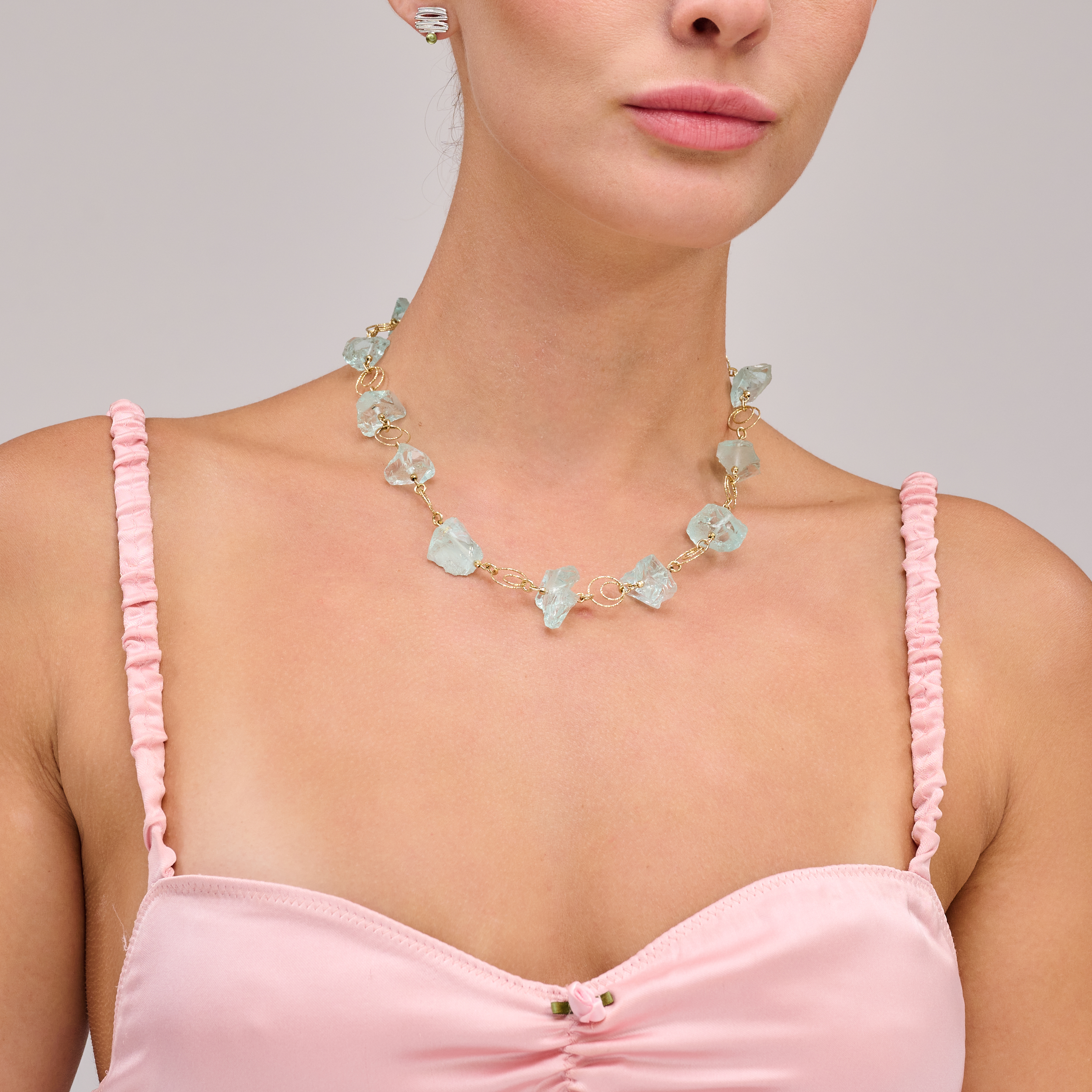 שרשרת כסף בציפוי זהב בעבודת יד, עם קוורץ תכלת רך ובוהק – תכשיט עדין ומיוחד, המשלב בין אור בהיר לרוך צבעוני טבעי. הקוורץ בגוון תכלת מעודן מעניק מראה קליל ואוורירי, כאילו נלקח ישירות מתוך שמיים נקיים או מי ים רגועים. הציפוי הזהוב מוסיף נגיעה של חמימות וזוהר, ומעצים את ההרמוניה בין אור חם לצבע קריר. זהו פריט שמתאים לנשים שמחפשות תכשיט עם נוכחות רכה אך בלתי נשכחת – שילוב של פשטות אלגנטית עם נגיעה צבעונית טבעית.