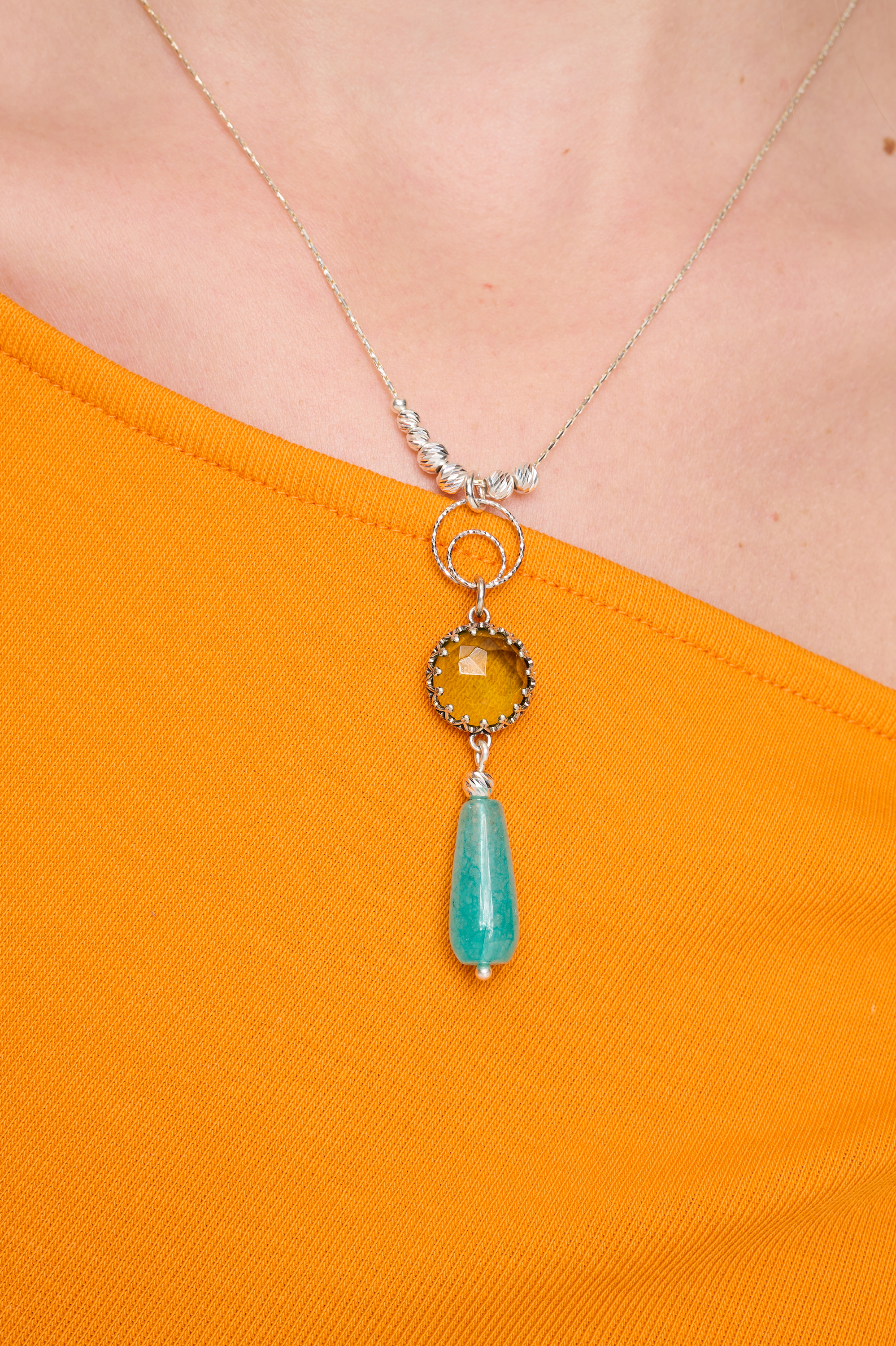 שרשרת כסף עם תליון מעוצב בעבודת יד, המשלב שלושה אבנים ייחודיות – אופלייט זוהר, טופז מבריק ואמזונייט בגוון ירוק תכלכל. שילוב שמביא אור, רוך ונגיעה של חופש. משתלב נהדר עם לבוש בהיר, שמלות קיץ או מראה בוהו שיק טבעי.