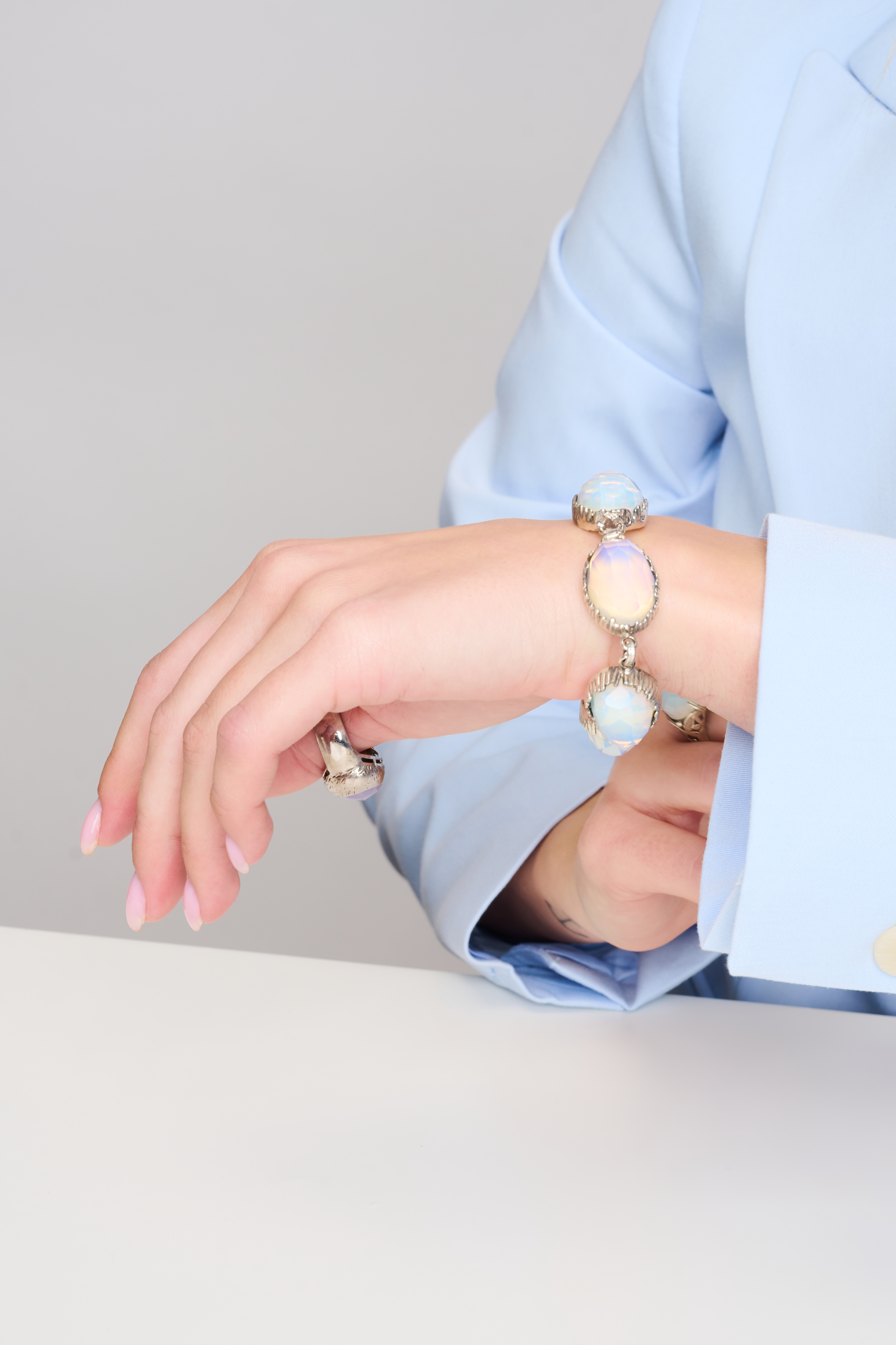 תכשיט בעיצוב יוצא דופן – צמיד מכסף סטרלינג עם חמישה שיבוצים של אופליט בגוון פניני שמשלב כחול, שמנת וזהב עדין באפקט זוהר. האבנים מלוטשות בגימור פאות ליצירת ברק פנימי רך. הצמיד מתאים לנשים שמחפשות מראה ייחודי ועדין, עם נגיעת קסם שמיימית. עיצוב שמחמיא לכל גוון עור ולכל הופעה, יום או ערב.

