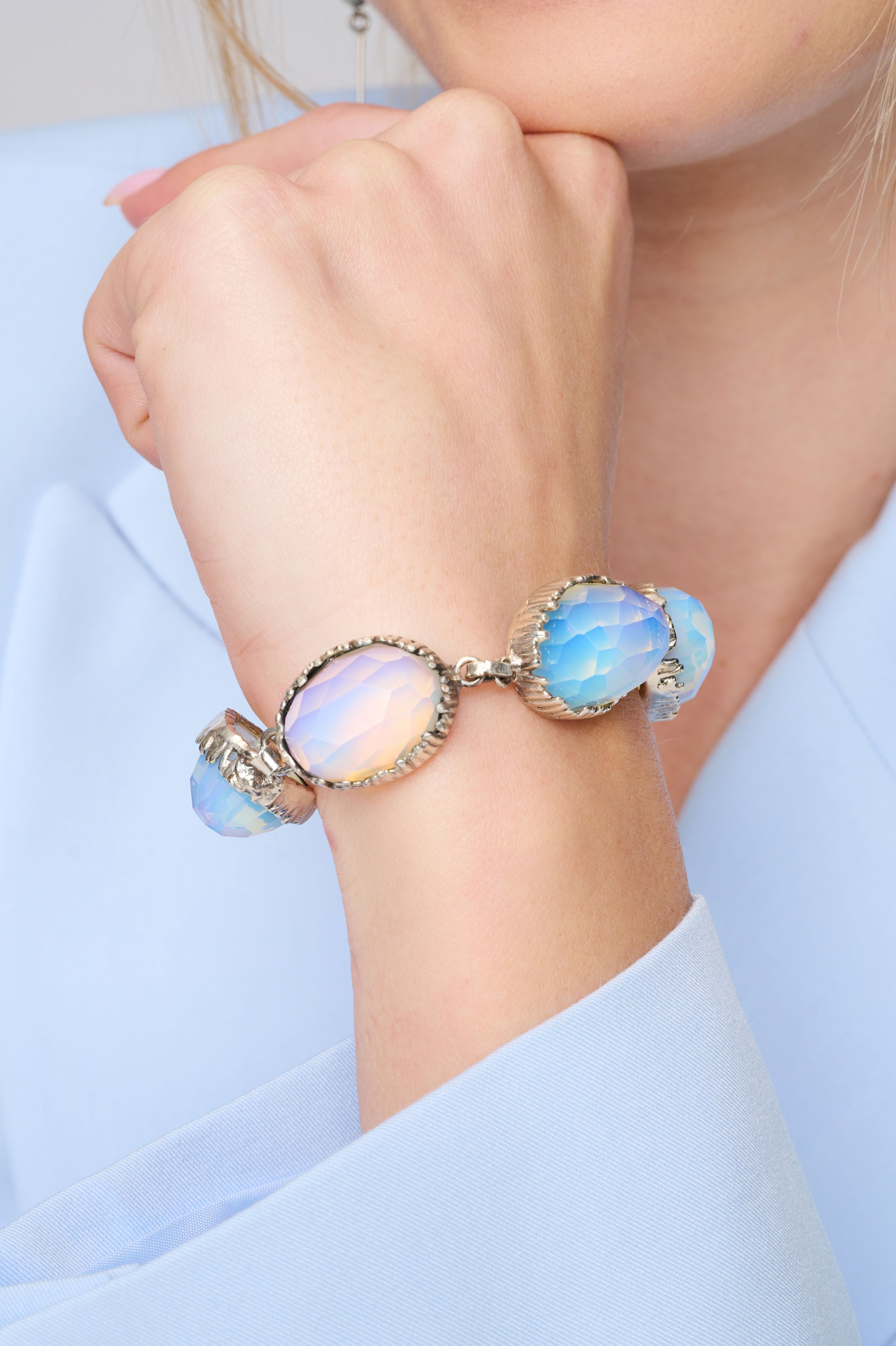 צמיד כסף סטרלינג יוקרתי בעבודת יד, משובץ באבני אופליט אובאליות בגוון חלבי-כחול עם פאות מבריקות. האבן משנה גוונים לפי התאורה, ממש כמו משחק של אור וענן. העיצוב כולל מסגרות כסף דקורטיביות עם סוגר מסוג טי-בר לנעילה קלה ובטוחה. תכשיט קלאסי עם מראה מהפנט – מתאים לנשים שאוהבות אלגנטיות עדינה עם טאץ' קסום. מושלם לאירועים, לחתונה או כמתנה עם נוכחות.

