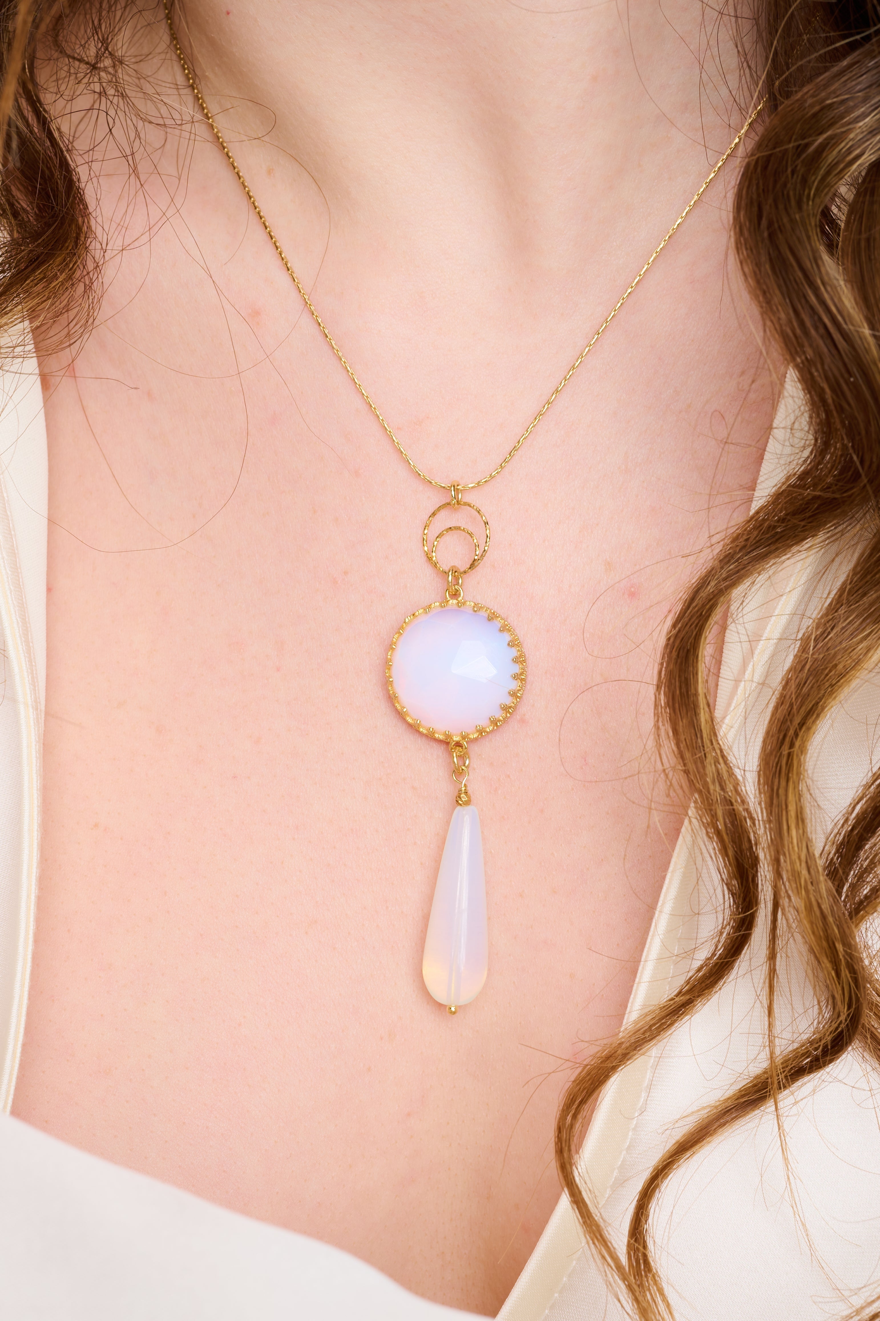 שרשרת כסף קלאסית עם תליון עדין המשובץ באופלייט לבן – אבן קסומה בגוון חלבי־פנינתי עם ברק פנימי רך, כמעט שקוף. האופלייט משנה את גווניו בעדינות לפי התאורה, וחושף נצנוצים בגווני תכלת, ורוד וזהב בהיר – כמו אור ירח שמשתקף בטיפה שקופה. התליון שומר על מראה אלגנטי ונקי, ומתאים לנשים שאוהבות תכשיטים בעלי נוכחות שקטה, מלאת אור ועדינות. תוספת מושלמת לכל הופעה – ליום עבודה, לערב חגיגי או כמתנה שמביאה איתה רוך, שלווה ויופי על־זמני.








