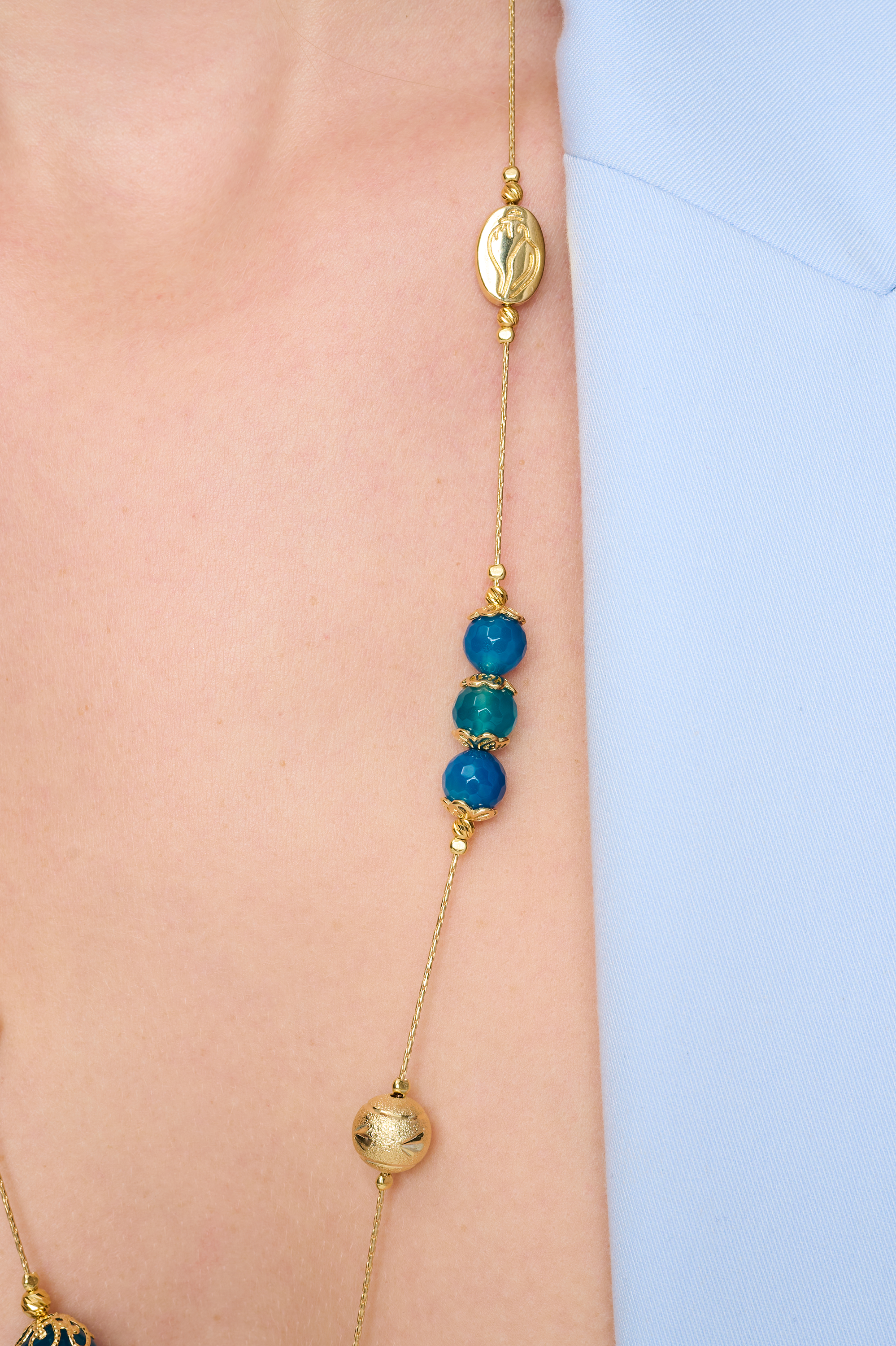 שרשרת ארוכה בעבודת יד מאבני אגט כחולות – מראה כחול עשיר שמקרין יציבות פנימית. החרוזים משתנים בין תכלת בהיר לכחול עמוק, מה שיוצר רכות צבעונית שמרגיעה את המבט. העיצוב הארוך מאפשר גמישות – ניתן לענוד את השרשרת באורך מלא או לעטוף פעמיים למראה רב-שכבתי. אבן האגט נחשבת לאבן הגנה והרגעה, ומוסיפה מגע מרפא שמקרין איזון פנימי. תכשיט מושלם למי שמחפשת גם צבע, גם סגנון וגם תחושת חיבור רגשי לטבע.