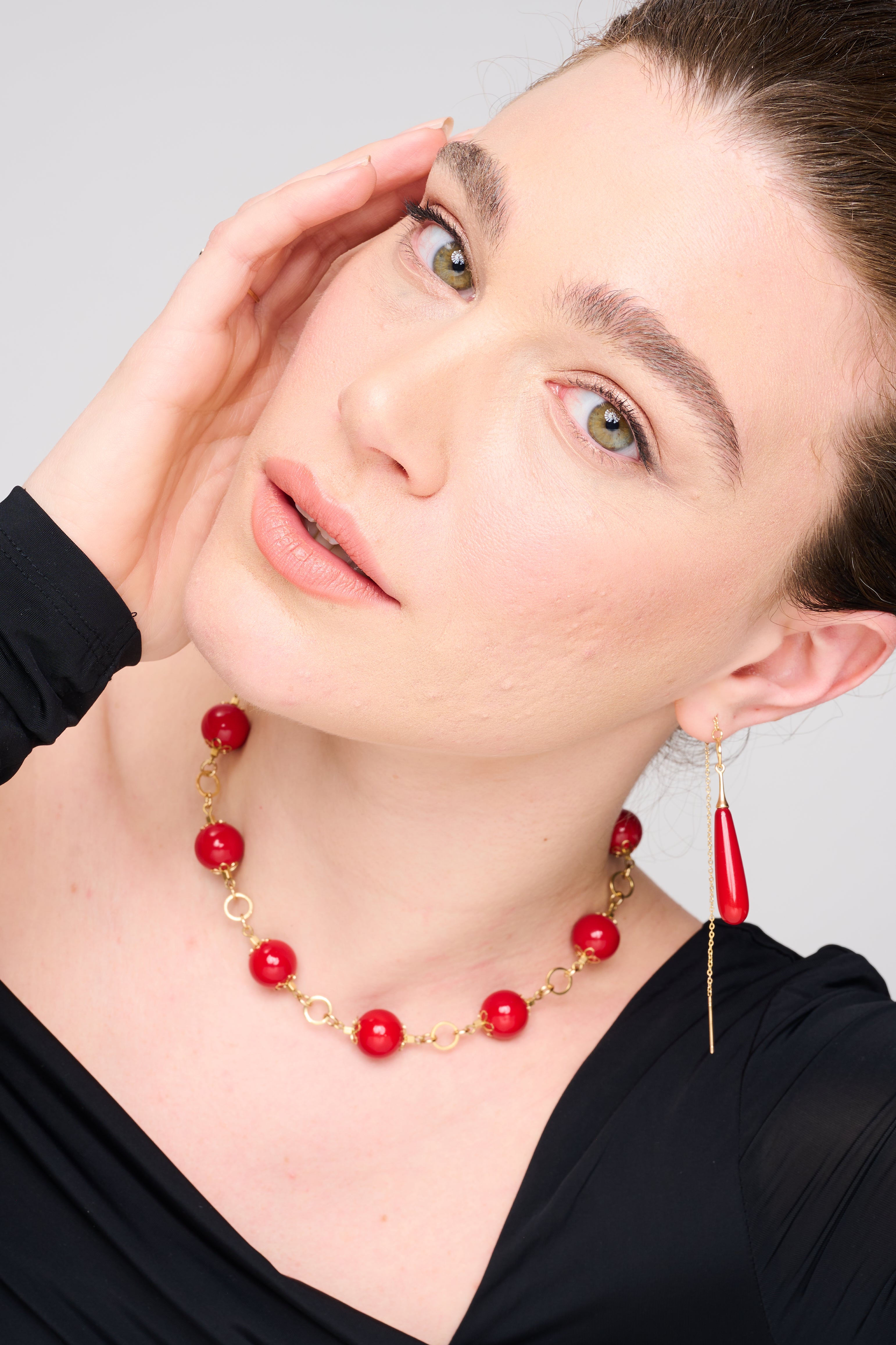 שרשרת אלגנטית המורכבת מחרוזים גדולים ועגולים בצבע אדום יין מבריק, מעוטרים באלמנטים מוזהבים בסגנון פרחוני המחברים בין החרוזים. עיצוב קלאסי ונשי, שמצטלם נהדר על רקע כהה ומעביר תחושת עוצמה, אופנתיות ורומנטיקה.

