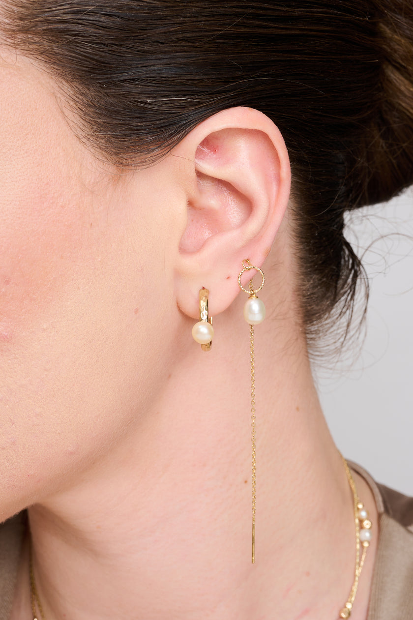 עגילי זהב 14 קראט עם פנינה מתורבתת התלויה בקצה כל עגיל מציעים שילוב מושלם של איכות ויוקרה בעיצוב שרשרת עדין. שרשרת הזהב הדקיקה נעה בחן עם כל תנועה, בעוד הפנינה הנוצצת בקצה מוסיפה נקודת אור קסומה לכל הופעה. עגילי פנינה יוקרתיים אלה מקרינים אלגנטיות נצחית ומתאימים במיוחד לערב יוקרתי, אך גם יוסיפו זוהר למראה יומיומי מתוחכם. העגילים מיוצרים בקפידה עם גימור מושלם, המדגיש את איכות הזהב ואת היופי הטבעי של הפנינה. זהו פריט חובה לאוהבות תכשיטי יוקרה המחפשות לשדרג כל הופעה בסטייל על-זמני.
