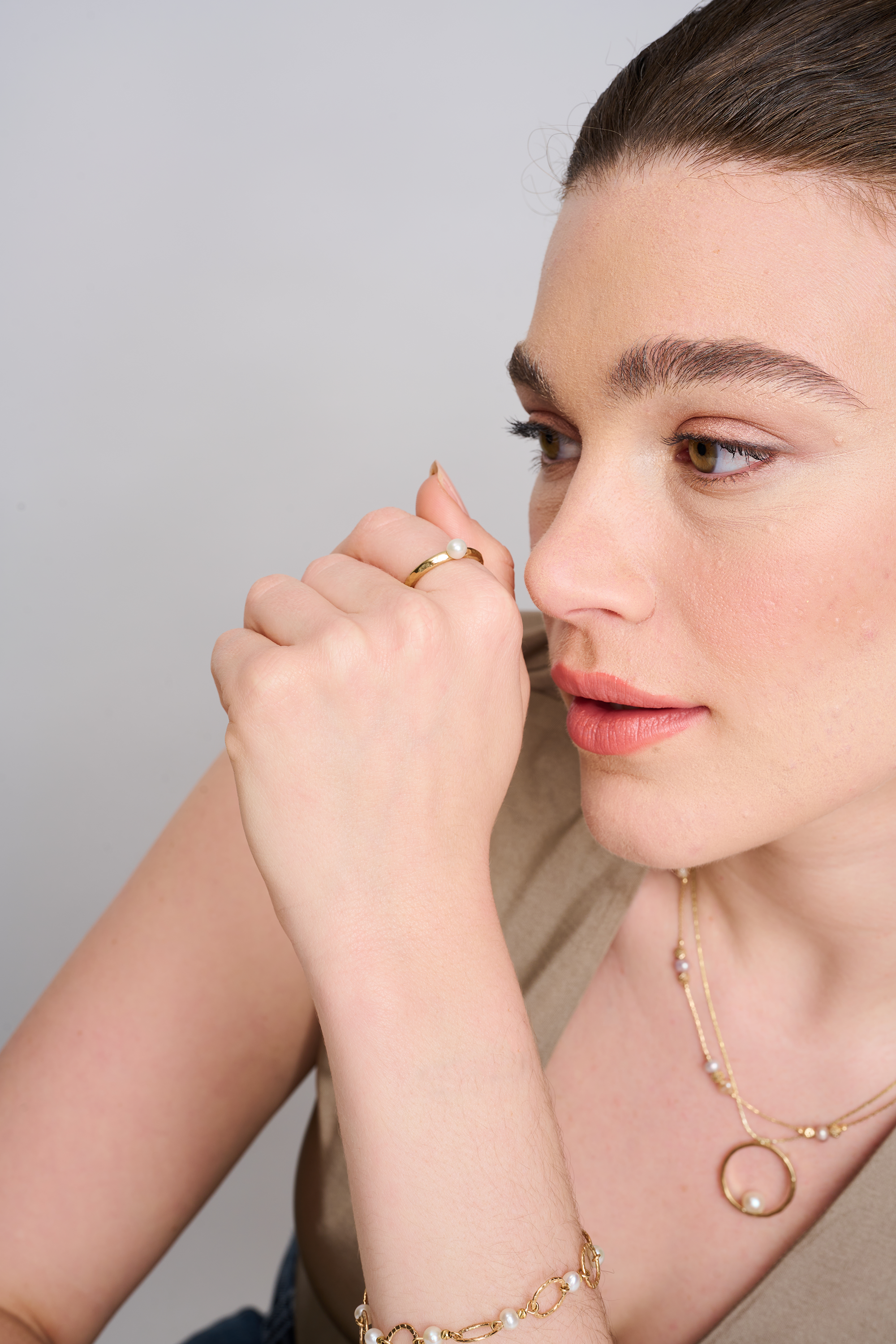 שרשרת בעיצוב אלגנטי עם אלמנט מרכזי מצופה זהב מבריק, המשובץ בפנינת שמנת מעודנת – תכשיט קלאסי בעל נוכחות בולטת. הפנינה ממוקמת במרכז התליון ומקרינה אור רך וטבעי, תוך יצירת ניגוד מחמיא עם הציפוי הזהוב. עיצוב השרשרת משלב בין עיצוב על־זמני עם טוויסט עדכני, ומתאים לאירועים חגיגיים כמו גם ללבוש יומיומי עם נגיעה נשית. פנינים ידועות כמשדרות תחושת רוגע ואלגנטיות – ויחד עם הזהב, נוצרת הרמוניה מושלמת בין אלגנטיות לחמימות.