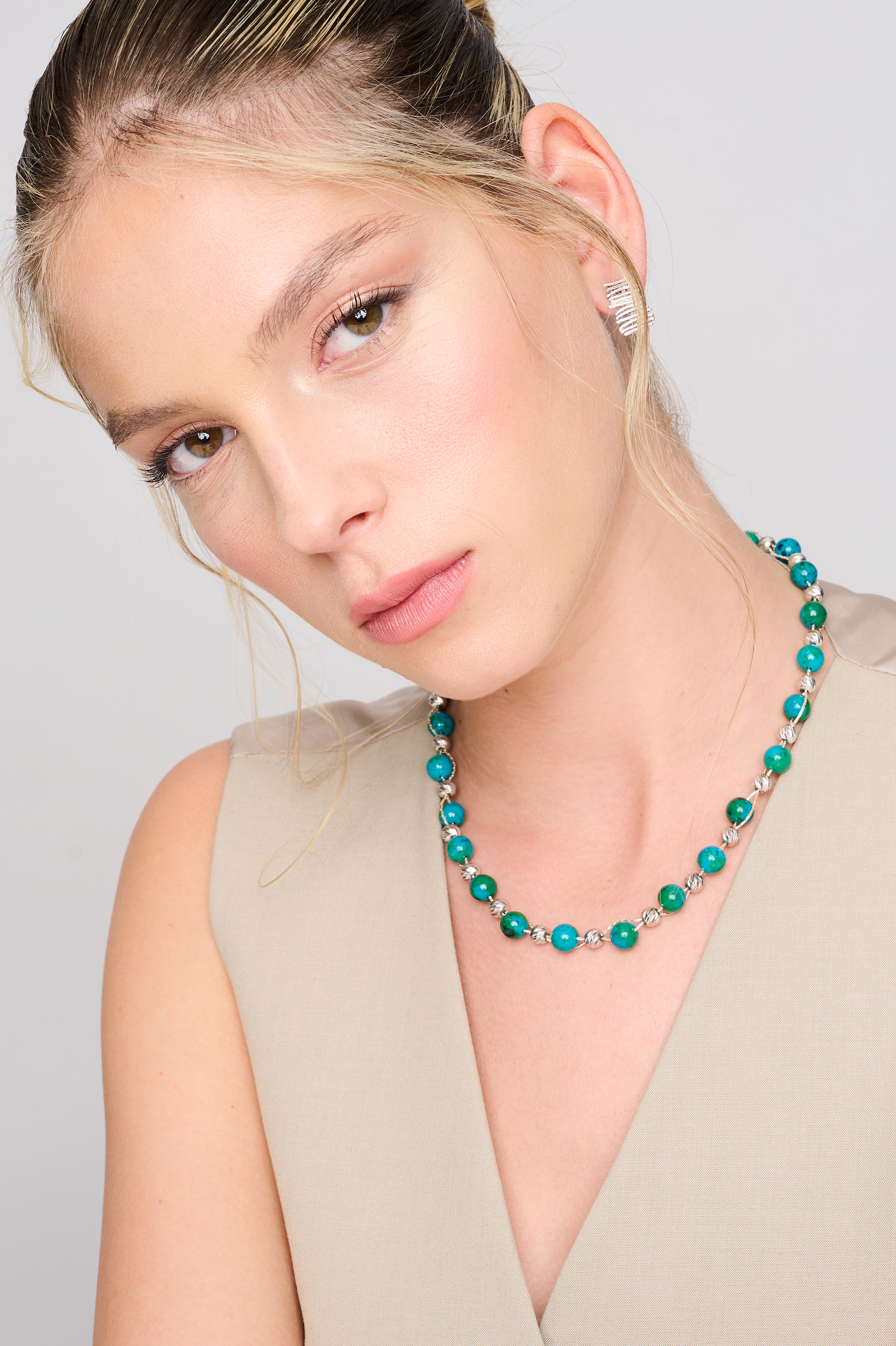 שרשרת עבודת יד מאבני כריסוקולה טבעיות בגווני טורקיז, ירוק וכחול עמוק – טקסטורה צבעונית שמחברת בין שקט לעוצמה. כל אבן נבחרת בקפידה ומציגה דפוס ייחודי משלה, הופך כל שרשרת לייחודית ובלתי חוזרת. הכריסוקולה ידועה כאבן המוכרת בכוחות ההרגעה והחיזוק שלה, כזו שמחברת את הלובשת לאנרגיה פנימית של שקט וביטחון. העיצוב של השרשרת שומר על קו נקי ומוקפד, ומבליט את יופיין הגולמי של האבנים. מתאים למי שמחפשת תכשיט שמדבר שקט – אך מלא נוכחות.