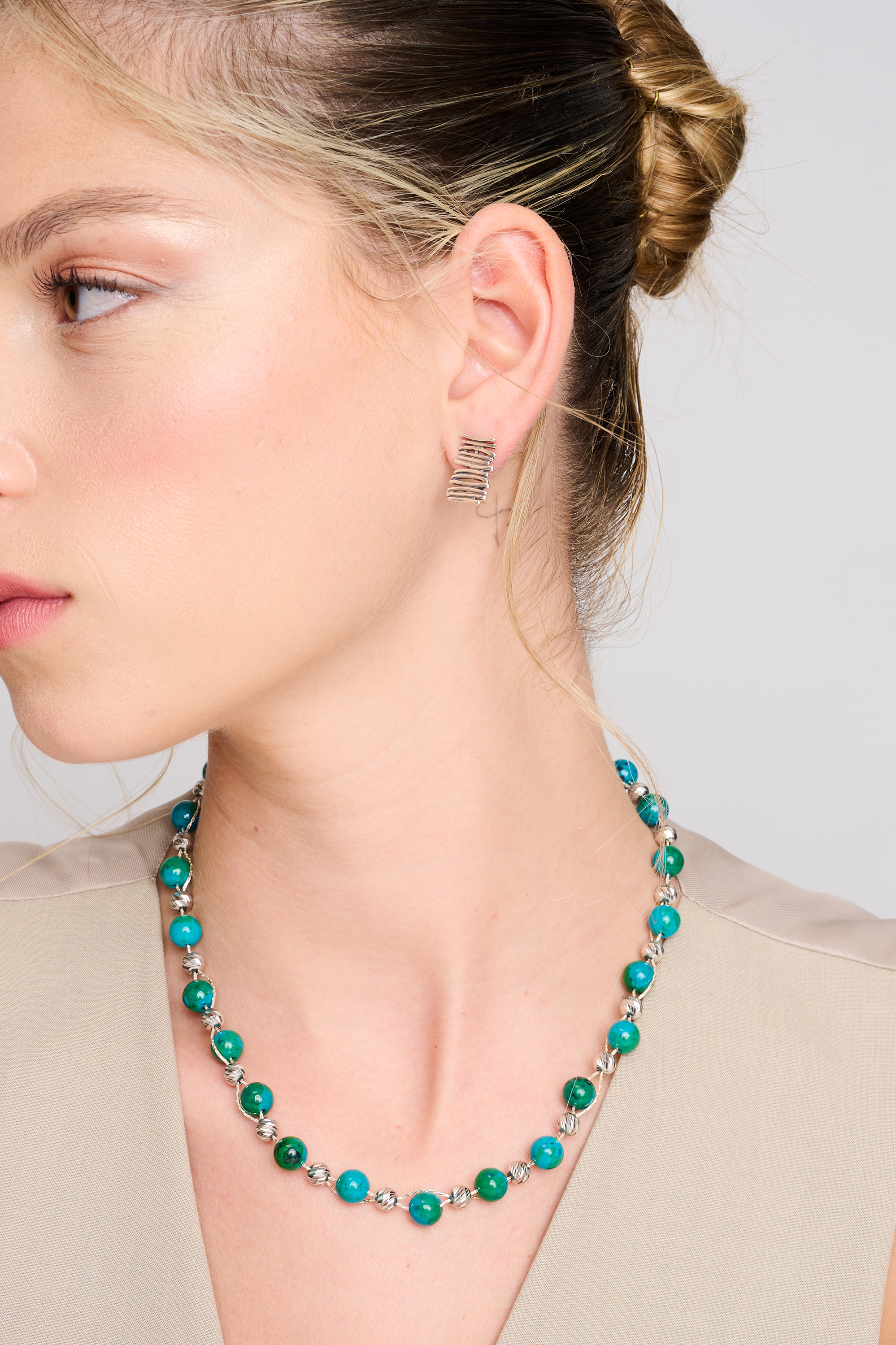 שרשרת עבודת יד מאבני כריסוקולה טבעיות בגווני טורקיז, ירוק וכחול עמוק – מפגש הרמוני בין גווני טבע עזים. כל אבן נבחרת בקפידה ומציגה דפוס ייחודי משלה, אין שתיים זהות – כל תכשיט מספר סיפור אחר. הכריסוקולה ידועה כאבן עם אנרגיה טבעית של שלווה והרמוניה, כזו שמחברת את הלובשת לאנרגיה פנימית של שקט וביטחון. העיצוב של השרשרת שומר על קו נקי ומוקפד, ומבליט את יופיין הגולמי של האבנים. מתאים למי שמחפשת עיצוב שכולו טבע, רגש ואיזון.