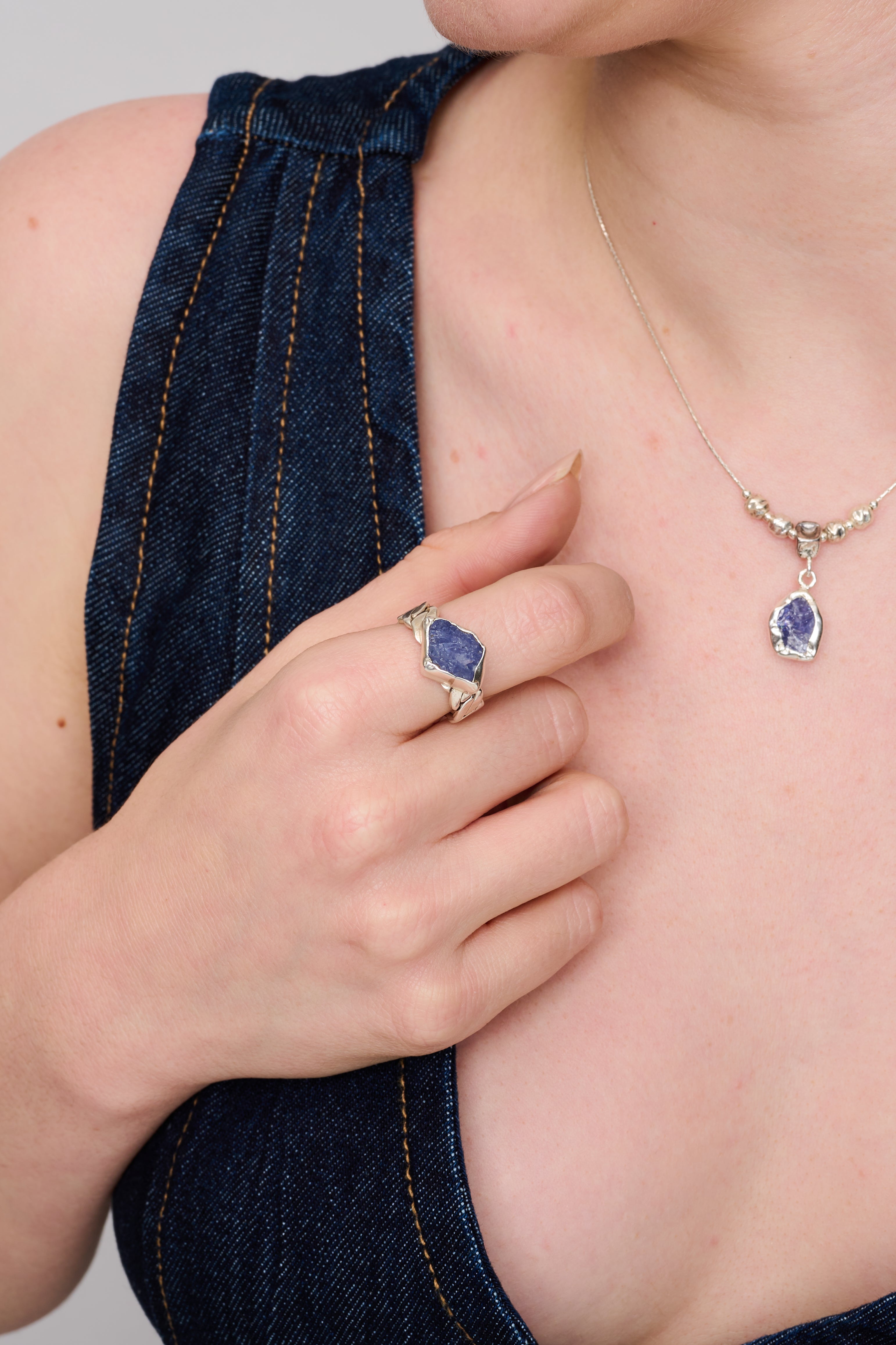 שרשרת עם שיק מודרני-קלאסי: בסיס דק ונקי בכסף סטרלינג, קו חרוזים עגולים כסופים שיוצרים עניין במרכז, ותליון אבן כחולה קטנה המשובצת במסגרת עגולה. האבן חצי-שקופה, בעלת עומק פנימי עדין, עם גוונים מתחלפים בין אפור תכול לכחול שמימי. מתאים לשימוש יומיומי או כשכבה עדינה מעל שמלה או חולצה פשוטה.

הטבעת להמחשה בלבד