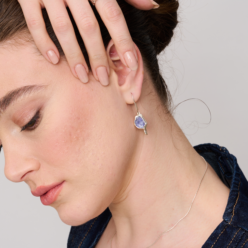 עגילי כסף עדינים בעבודת יד, עם טנזנייט אמיתי בגוון כחול-סגלגל עמוק שמחליף גוונים באור. שילוב מרשים של חומר טבעי נדיר ועיצוב קלאסי שמתאים ליומיום או לערב. תכשיט שמקרין יוקרה שקטה וסטייל אישי, ומתאים לנשים שמעריכות עבודת יד וחומרים איכותיים בעלי ערך רוחני וויזואלי.

