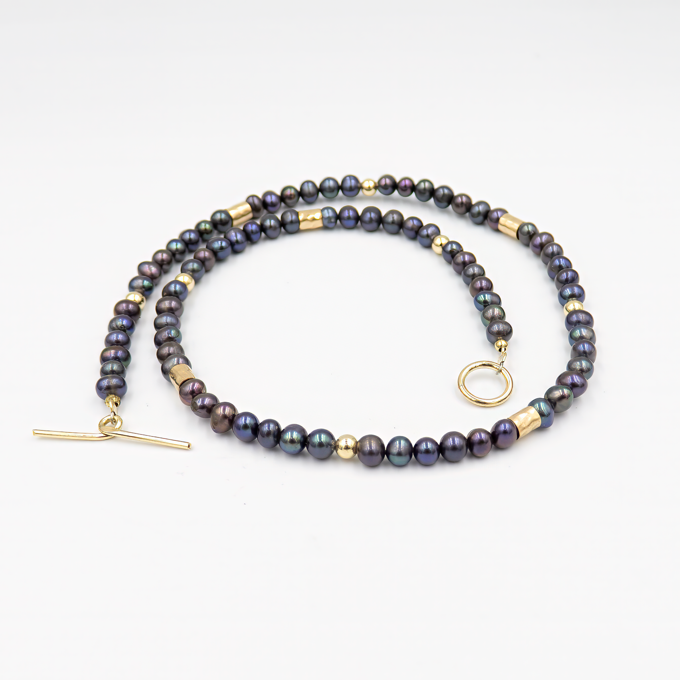 עיצוב יוקרתי עם שילוב של פנינים כהות וזהב – קולר עם אמירה מסוגננת, שמשלב בין עומק אלגנטי לנגיעה חמימה של זהב. הפנינים השחורות יוצרות נוכחות דרמטית אך הרמונית, ואילו חרוזי הגולדפילד מוסיפים קונטרסט זוהר ושיק עכשווי. העיצוב הצמוד לצוואר מדגיש את קווי המתאר ומעניק מראה נשי, חזק ומתוחכם. תכשיט פריט ורסטילי שמשדר יוקרה ורוך.