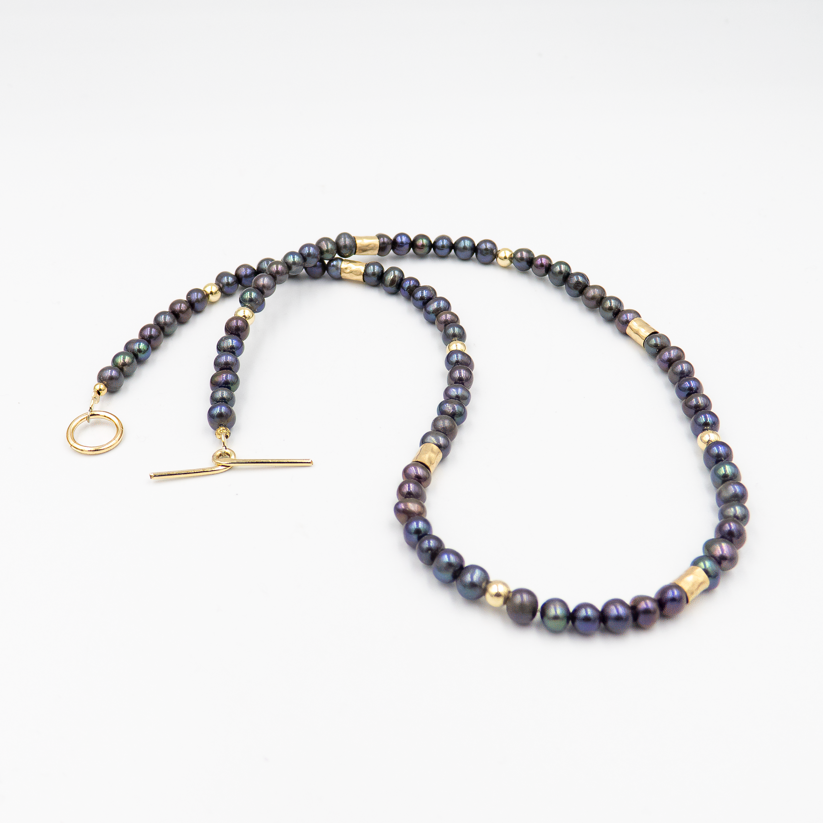 שרשרת צמודה עם פנינים שחורות ואלמנטים מוזהבים – פריט אופנתי בעל נוכחות שקטה, שמשלב בין עומק אלגנטי לנגיעה חמימה של זהב. הפנינים השחורות יוצרות נוכחות דרמטית אך הרמונית, ואילו חרוזי הגולדפילד מוסיפים קונטרסט זוהר וקו עיצובי נקי אך מרשים. העיצוב הצמוד לצוואר מדגיש את קווי המתאר ומעניק מראה נשי, חזק ומתוחכם. תכשיט למראה חגיגי או כטאץ’ מדויק ביומיום.