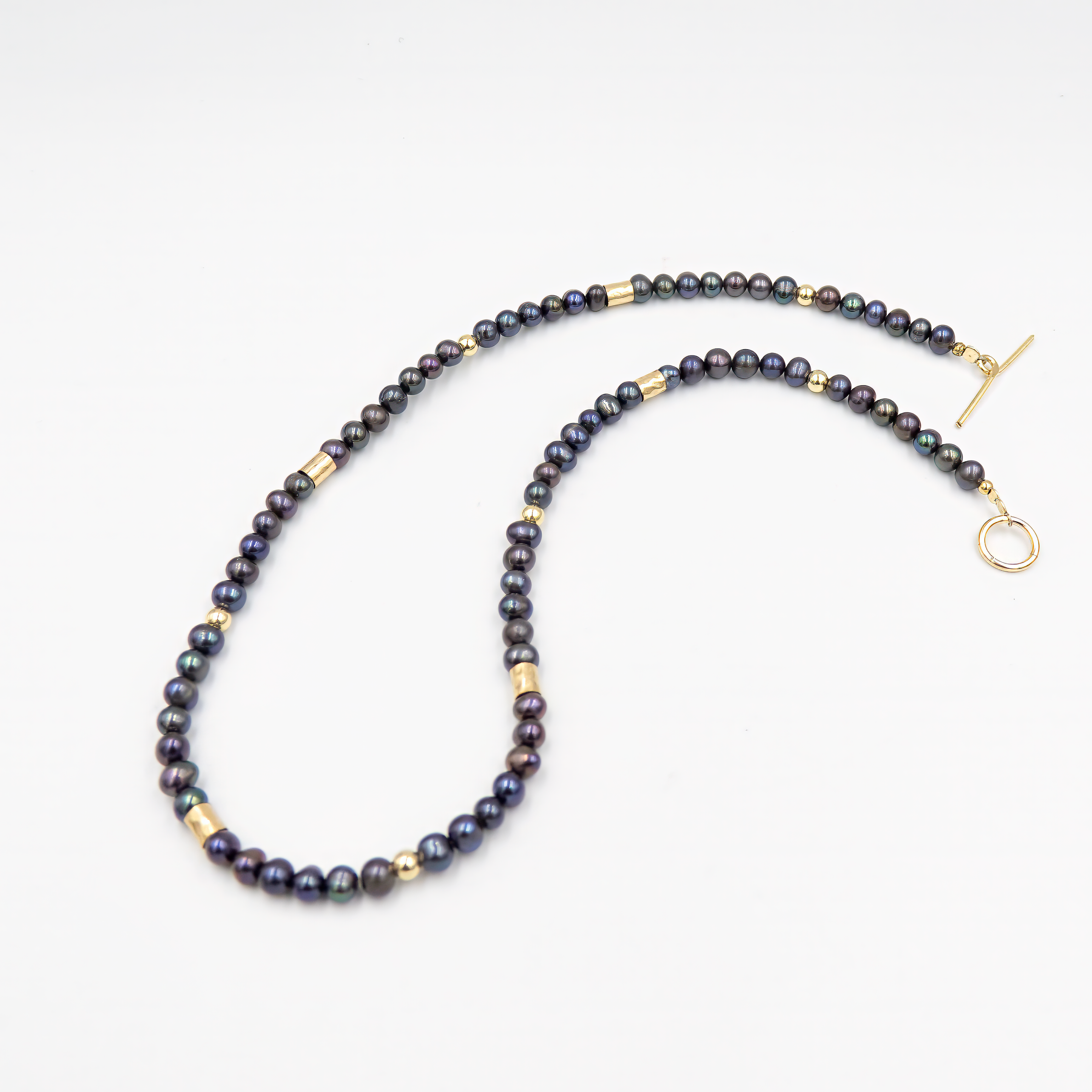 קולר ייחודי ואלגנטי המשלב פנינים שחורות עם חרוזי גולדפילד מוזהבים – תכשיט בעל נוכחות דרמטית אך מעודנת. הפנינים הכהות מעניקות עומק ועוצמה, והגולדפילד מוסיף אור חמימה וזוהר זהוב. השילוב בין השחור למוזהב יוצר ניגוד מהפנט ונשיות מודרנית. הקולר צמוד לצוואר ומעניק מראה אלגנטי, מתוחכם ובלתי נשכח – מושלם לאירועים או למראה ערב עם נגיעה של עוצמה שקטה.